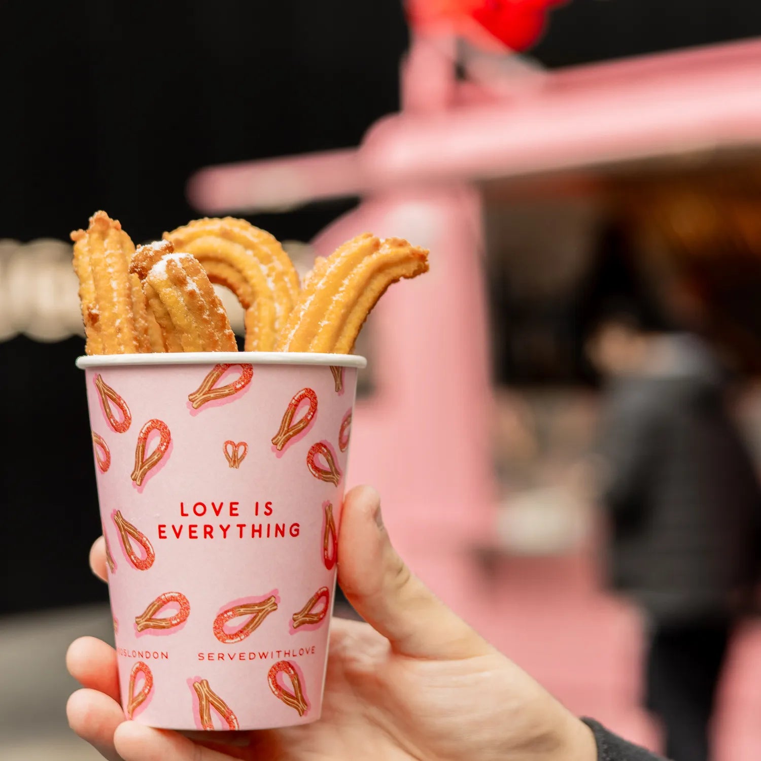Golden cinnamon-sugar churros in a Love Churros cup